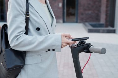 Akıllı telefonlu bir iş kadını mobilet kiralamak için mobil uygulama kullanıyor.