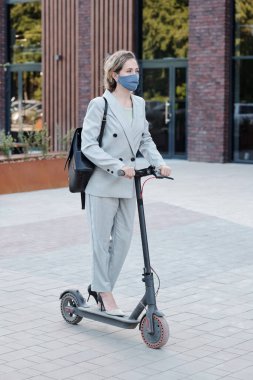 Çağdaş takım elbiseli kadın mobiletle işe gidiyor.