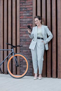 İyi giyimli bir iş kadını açık havada görüntülü sohbet yoluyla konuşuyor.