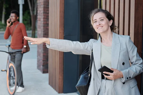 Femme d'affaires souriante attrapant taxi à l'extérieur — Photo