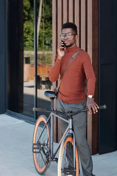 Stilvoller Afrikaner mit Fahrrad steht vor modernem Gebäude — Stockfoto