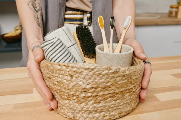 Mains de jeune femme en bonne santé tenant panier avec serviettes et brosses — Photo