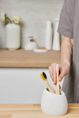 Diş fırçalarından birini alan genç bir kadın.