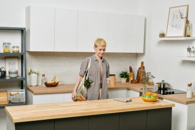 Mutfak masasında içki içen genç bir kadın.