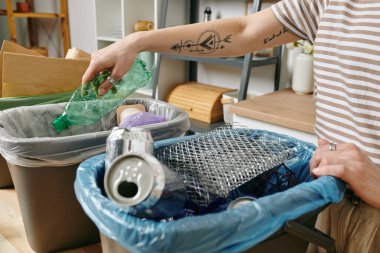 Kolunda dövmesi olan, çöp toplayan bir kadın.