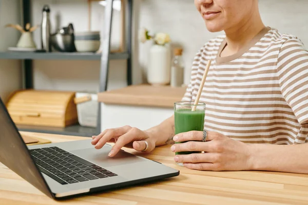 Σύγχρονη γυναίκα με ποτό κάθεται μπροστά από το laptop — Φωτογραφία Αρχείου