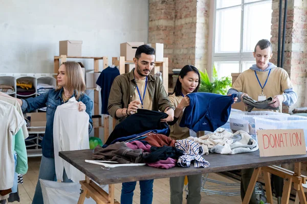 Intercultural people choosing donation clothes — Stock Photo, Image