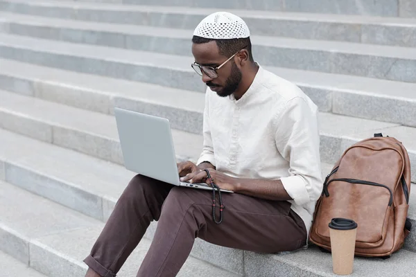 Homme musulman noir concentré utilisant un ordinateur portable — Photo