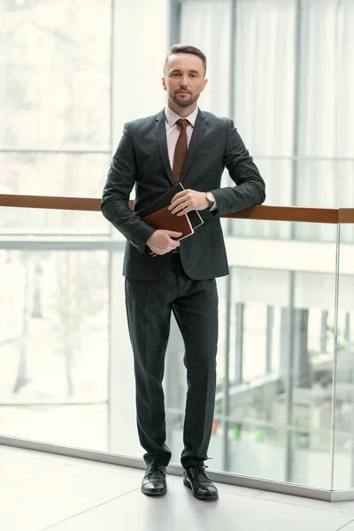 Businessman with folders standing at office — Stock Photo, Image