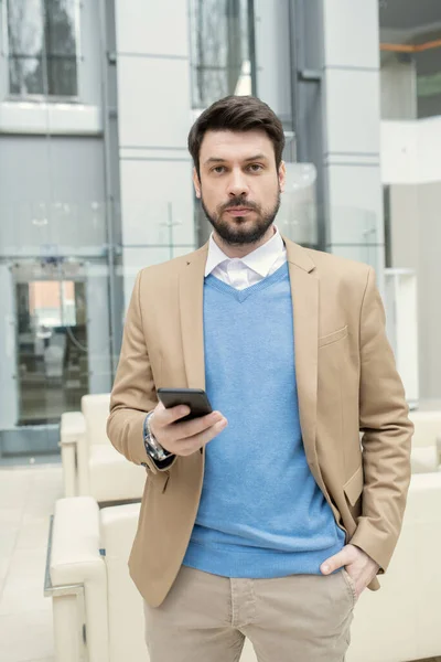 Businessman with phone standing at office — Stock Photo, Image