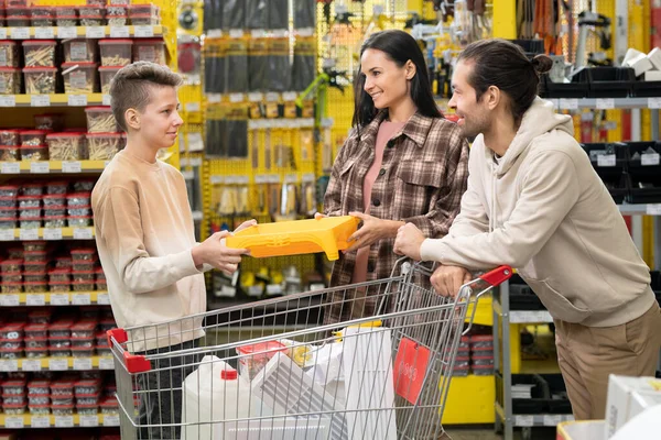 Семья из трех человек выбирает товары в магазине — стоковое фото