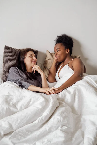 Duas meninas interculturais relaxando na cama — Fotografia de Stock