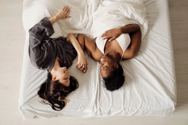 Alegre pareja lesbiana acostada en la cama —  Fotos de Stock