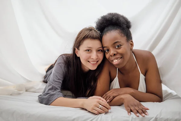 Duas meninas lésbicas alegres deitado perto um do outro na cama — Fotografia de Stock