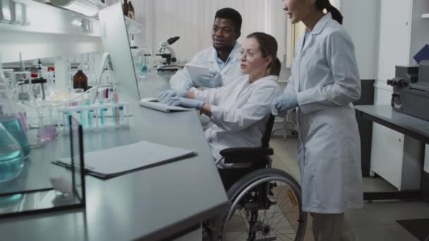 Beyaz Önlüklü Eldivenli Erkek Kadın Bilim Adamlarının Araştırma Sonuçlarına Bakıp — Stok video