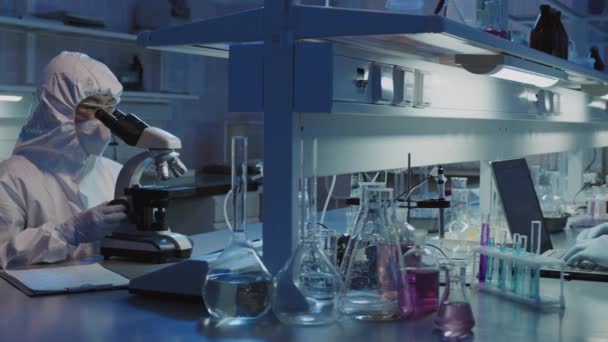 穿一次性工作服和戴口罩的流行病学小组在实验室工作的Pan慢速 — 图库视频影像