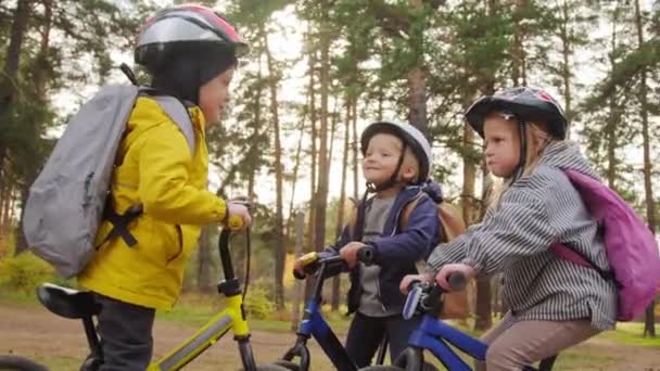 Ruční Záběr Roztomilých Chlapců Dívek Helmách Batohy Sedí Vyváženém Kole — Stock video