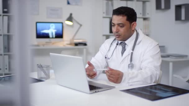 Orta Yaşlı Genç Bir Orta Doğulu Doktorun Bilgisayarının Önünde Oturmuş — Stok video