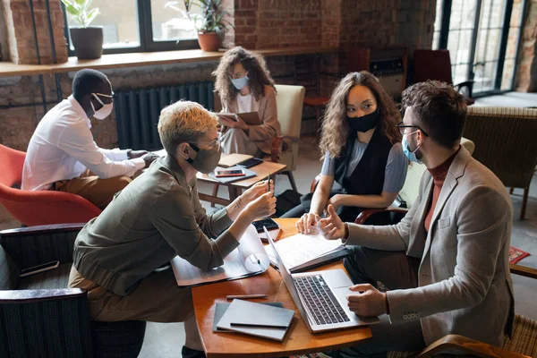Group of managers in masks working over new business project — Stock Photo, Image