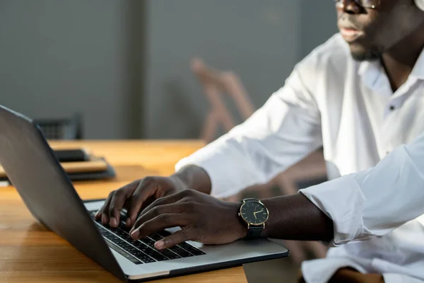 Uomo d'affari africano in camicia bianca digitando sulla tastiera del computer portatile — Foto Stock