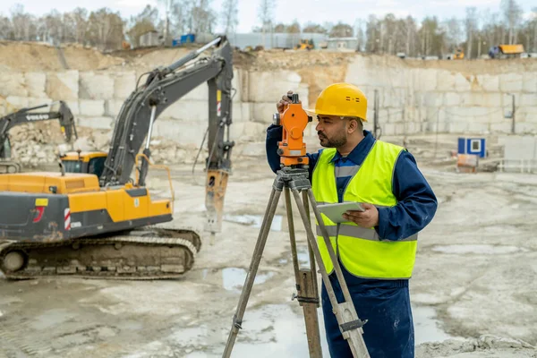 Enhetlig besiktningsman vid totalstationen på byggarbetsplatsen — Stockfoto