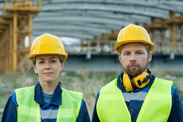 Ingenieros en cascos de trabajo de pie al aire libre —  Fotos de Stock