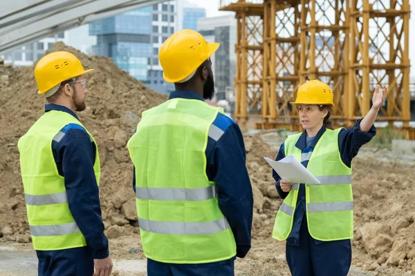 Capataz com trabalhadores que trabalham no canteiro de obras — Fotografia de Stock