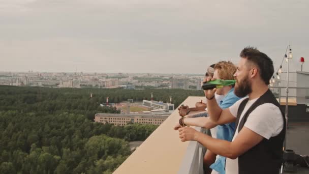 Arkadaşların Çatıdaki Terasta Dikilip Manzaraya Bakarken Bira Içip Sohbet Etmelerinin — Stok video