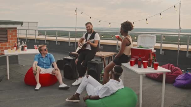 Rastreamento Lento Jovem Barbudo Tocando Guitarra Para Seus Amigos Terraço — Vídeo de Stock