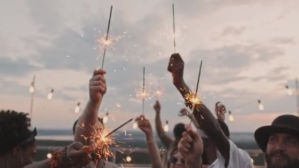 Tiro Médio Jovens Felizes Segurando Sparklers Desfrutando Festa Telhado Noite — Vídeo de Stock