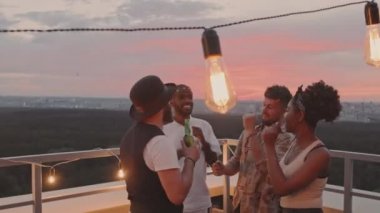 Yaz akşamları çatıdaki terasta dans eden genç erkek ve kadının el kamerasıyla çekilmiş görüntüleri.