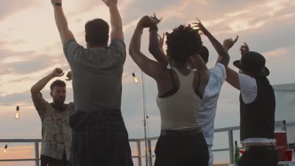 Çatıdaki Partide Çalarken Dans Eden Zıplayan Gençlerin Düşük Açılı Görüntüleri — Stok video