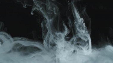 Suyun altından siyah arkaplana doğru akan beyaz boya girdaplarının soyut arkaplan çekimi