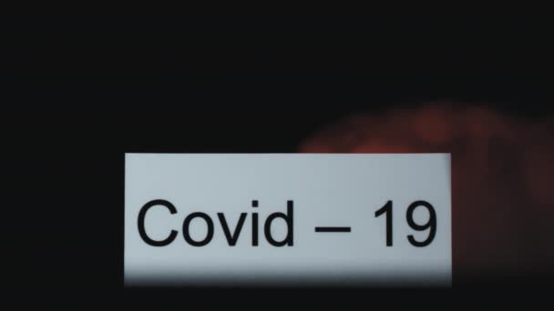 単語Covid 19で赤い煙のサインを包み込むのワイプの遅いショットを閉じます — ストック動画