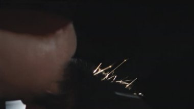 Siyah arkaplanda izole edilmiş çakmağı ateşleyen tanınmayan kişiye aşırı yakın çekim