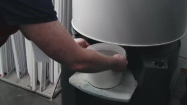 Tanımlanamayan erkek hırdavatçı dükkanının yavaş çekimleri karıştırma makinesine bir kova boya koyuyor.