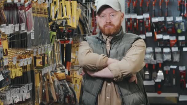 Kabarık Yelek Şapkalı Erkek Müşterinin Portresi Kollarını Kavuşturup Hırdavatçıda Kameraya — Stok video