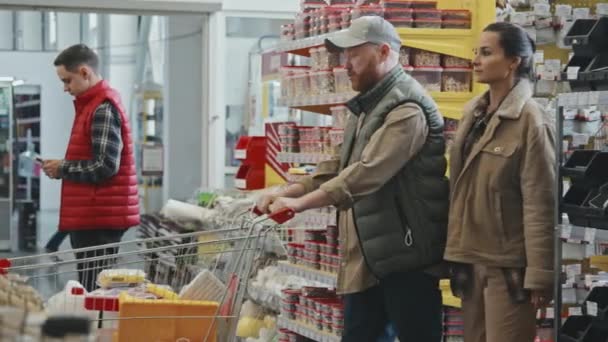 Langsam Läuft Ein Paar Mit Einkaufswagen Durch Belebten Baumarkt — Stockvideo