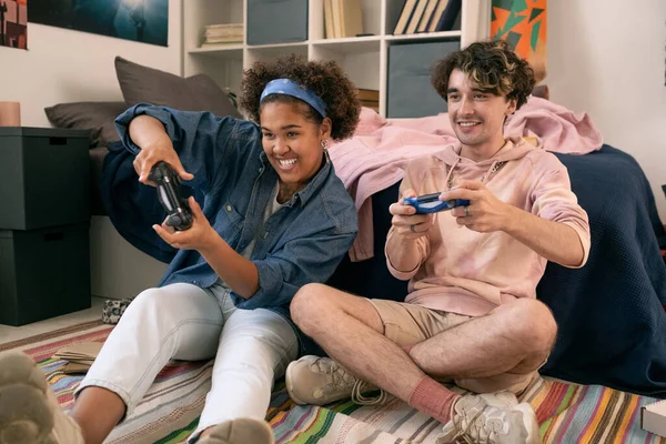 Adolescentes felices con joysticks jugando videojuego en el dormitorio —  Fotos de Stock