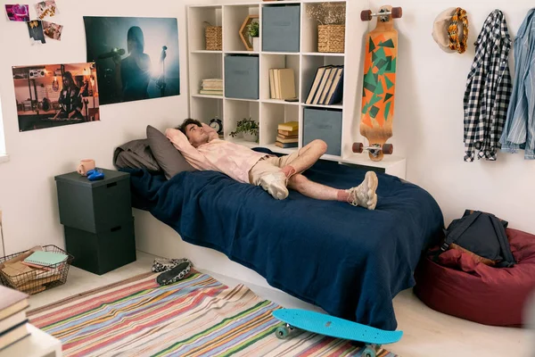 Jongeman liggend op bed terwijl hij rust en nadenkt — Stockfoto