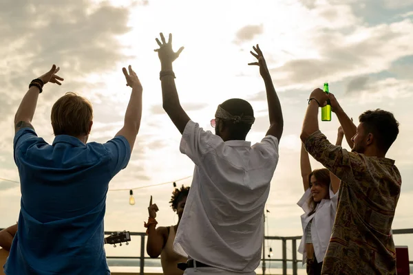 Χαρούμενοι φίλοι με μπύρες να σηκώνουν τα χέρια ενώ χορεύουν — Φωτογραφία Αρχείου