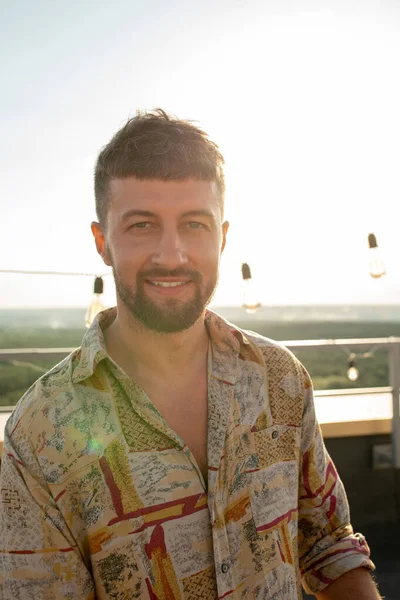 Happy young man looking at camera at rooftop party — Stock Photo, Image