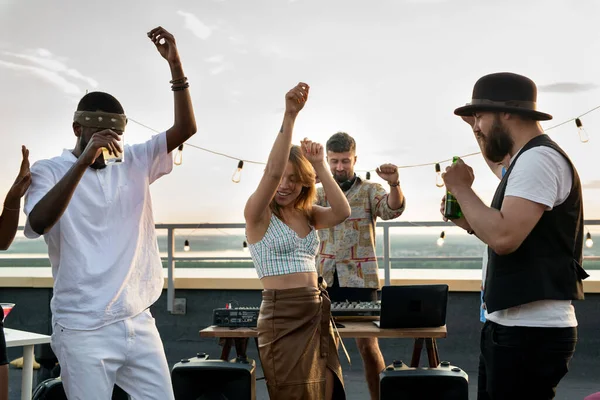 Jóvenes amigos interculturales y DJ bailando juntos en la fiesta en la azotea —  Fotos de Stock