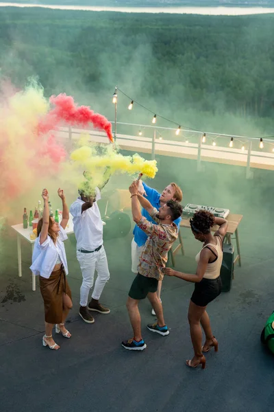 Jóvenes interculturales con galletas de humo bailando juntos —  Fotos de Stock