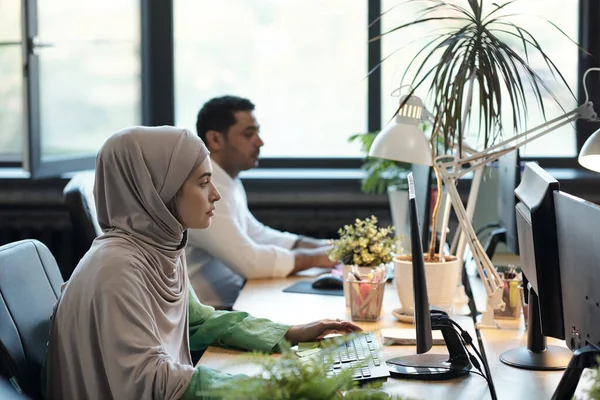 Joven empresaria en hijab y su colega masculino de informática por lugar de trabajo —  Fotos de Stock