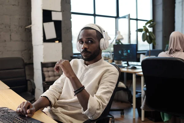 Jonge Afrikaanse zakenman kijkt naar camera vanaf de werkplek — Stockfoto