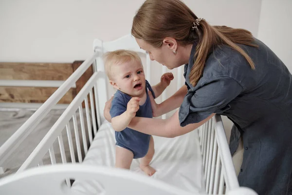 Young Mother Ponytail Taking Frightened Baby Arms Crib — Stock Photo, Image