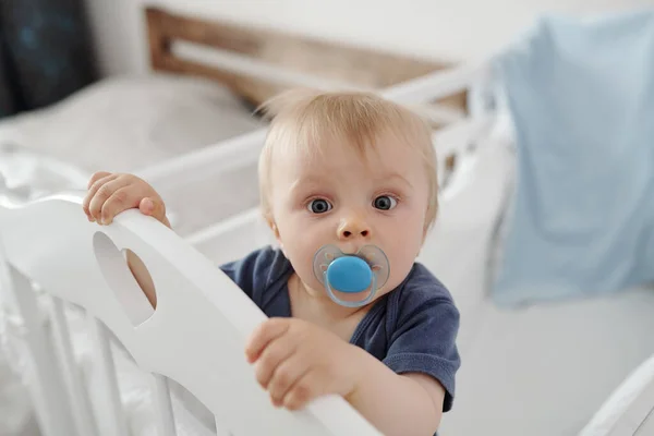 Retrato Bebê Loiro Curioso Com Manequim Segurando Lado Barrado Berço — Fotografia de Stock