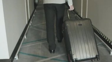 Uzun ve boş otel koridorlarında odasını ararken, kendine güveni tam bir iş adamının bagajını dikiz aynasından çekerken.