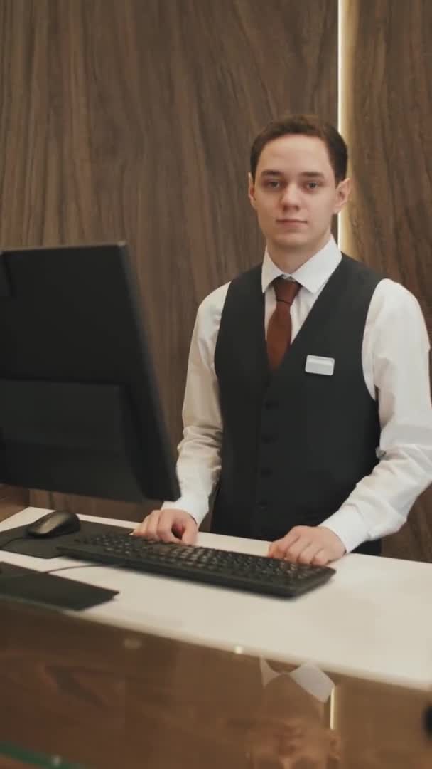 Vertical Średnio Powolny Portret Młodego Mężczyzny Recepcjonisty Lub Menedżera Hotelu — Wideo stockowe